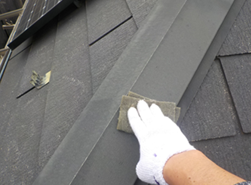 屋根の板金部をケレン（ヤスリ掛け）を行っています。