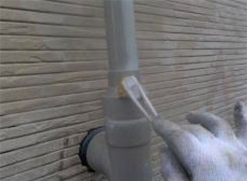 配管の下塗り（密着剤塗装）の様子です。